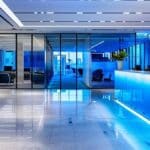 a sleek, modern office workspace is illuminated by cool blue lighting, featuring a large digital display showcasing a complex interface of electronic identity verification processes with vivid graphics representing database cross-checks and secure data flows.